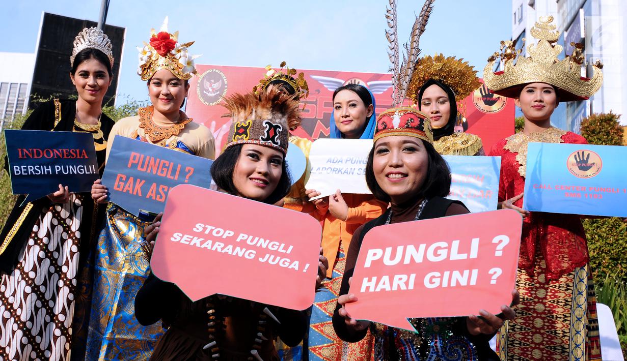 Petugas berpakaian adat daerah menunjukkan tulisan saat social community gathering Satgas Saber Pungli di Jakarta, Minggu (17/9). Kemenko Polhukam meluncurkan maskot dan melakukan sosialisasi satgas saber pungli. (Liputan6.com/Helmi Fithriansyah) 