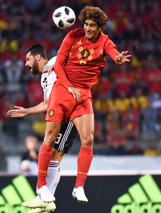 Pemain Belgia Marouane Fellaini berebut bola di udara dengan pemain Mesir Ahmed Elmohamady saat laga persahabatan di stadion King Baudouin di Brussels (6/6). (AP/Geert Vanden Wijngaert)