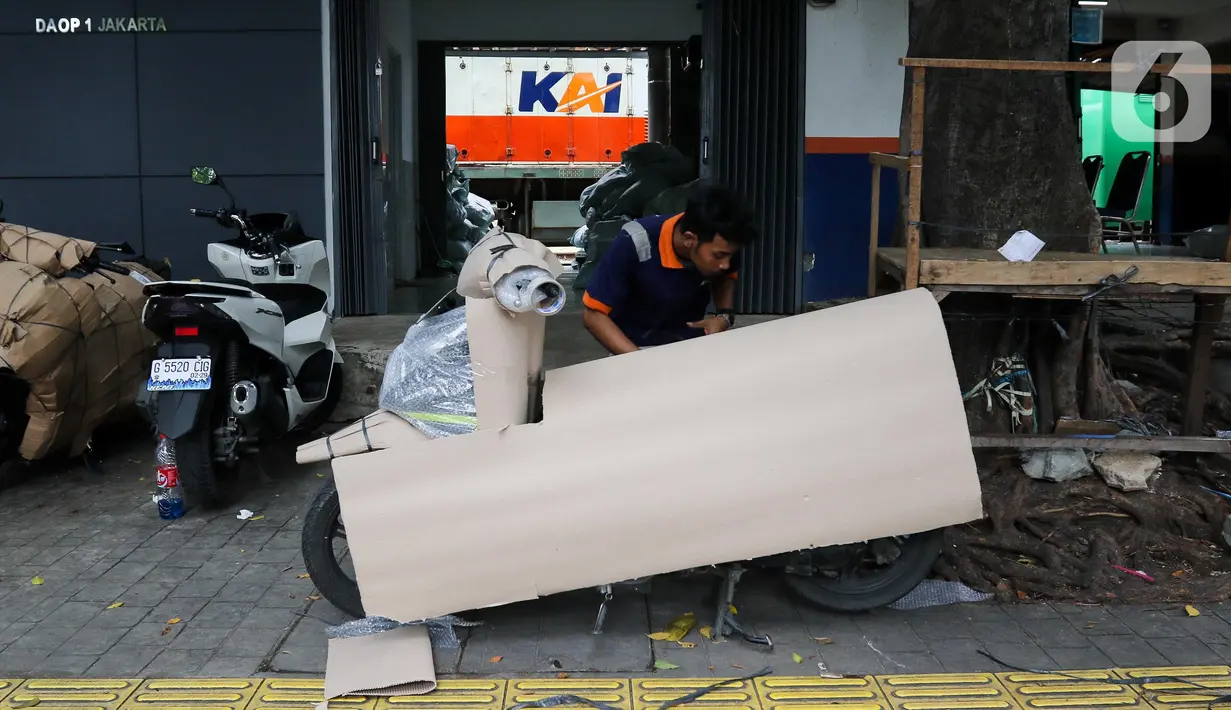 Pekerja mengemas motor untuk dikirim melalui salah satu jasa pengiriman logistik di kawasan Pasar Senen, Jakarta, Minggu (23/3/2025). (Liputan6.com/Herman Zakharia)