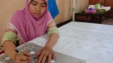 Pengrajin melukis motif sasirangan yang diinginkan di atas kain ukuran 2 meter menggunakan kain katun dan sutera di daerah Sasiranga, Banjarmasin, Kalimantan Selatan (16/1/2017). (Liputan6.com/Novi Nadya)