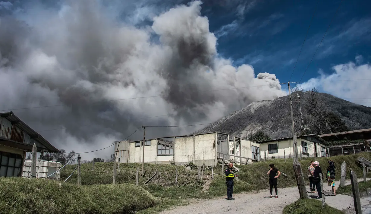 Petugas mengevakuasi warga yang tinggal di dekat gunung Turrialba yang memuntahkan abu vulkanik saat erupsi, terlihat dari Cartago, 35 km dari San Jose, Kosta Rika (6/1). (AFP Photo/Ezequiel Becerra)