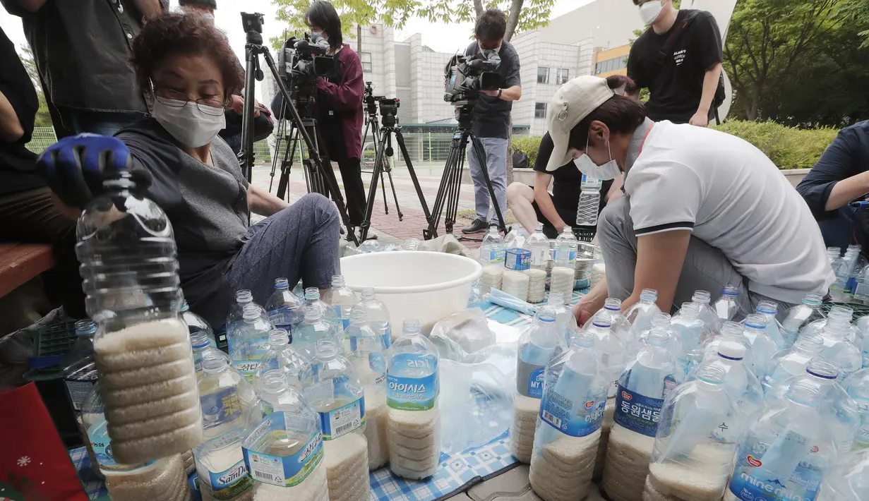 Para pembelot Korea Utara mengisi botol-botol plastik dengan beras dan masker untuk dikirim ke Korea Utara dengan balon, Seoul, Korea Selatan, Kamis (18/6/2020). Tindakan pembelot membuat Korut menutup semua jalur komunikasi dan meledakkan kantor penghubung dengan Korsel. (AP Photo/Ahn Young-joon)