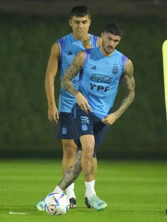 Rodrigo De Paul memainkan bola di depan Paulo Dybala saat sesi latihan di Stadion Universitas Qatar, Doha, Qatar, Senin (5/12/2022). Pada ajang Piala Dunia 2006 dan 2014 Argentina tak terkalahkan dalam dua pertemuan terakhirnya dengan Belanda. (AP Photo/Jorge Saenz)