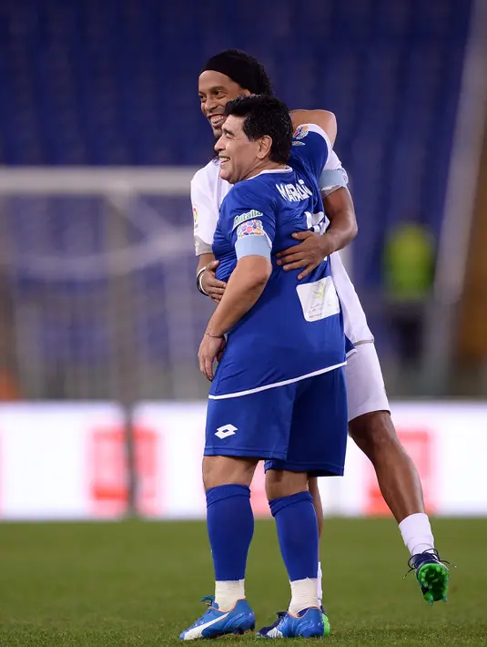 Marodana memeluk mantan pemain Barcelona, Ronaldinho usai pertandingan amal 'United for Peace' di stadion Olimpyco, Roma, Italia (12/10). Lebih dari 20.000 penonton menyaksikan pertandingan tersebut. (AFP Photo/Filippo Monteforte)