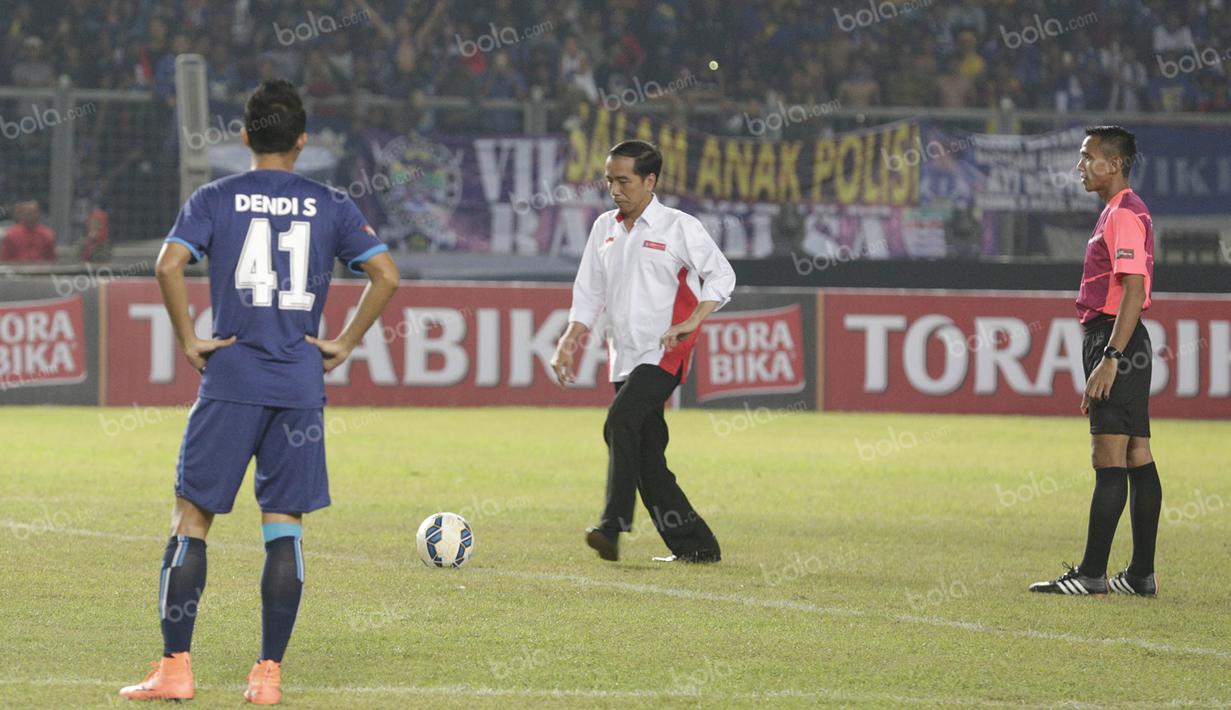 Presiden Joko Widodo, bersiap menendang bola membuka final Torabika Bhayangkara Cup 2016 antara Arema Cronus melawan Persib Bandung di SUGBK, Jakarta, Minggu (3/4/2016). (Bola.com/Vitalis Yogi Trisna)