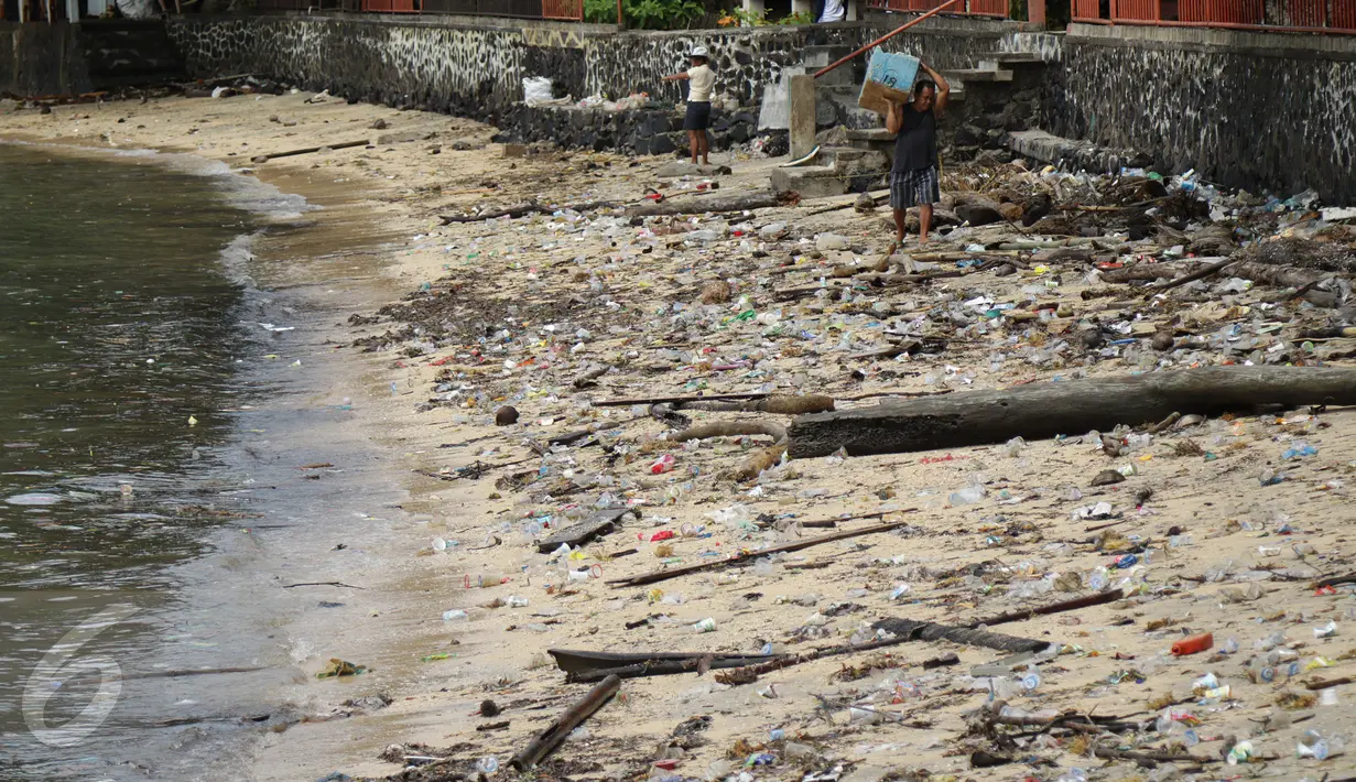 Warga berjalan melintasi sampah yang berserakan di pinggir pantai Pulau Bunaken, Manado, Sabtu (17/12). Banyak wisatawan mengeluhkan keberadaan sampah, terutama sampah plastik yang dirasa sudah sangat menganggu. (Liputan6.com/Fery Pradolo)