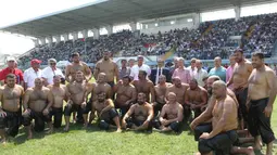Semua peserta berfoto bersama sebelum memulai pertandingan yang digelar di sebuah stadion sepak bola. (AFP Photo/Adem Altan)