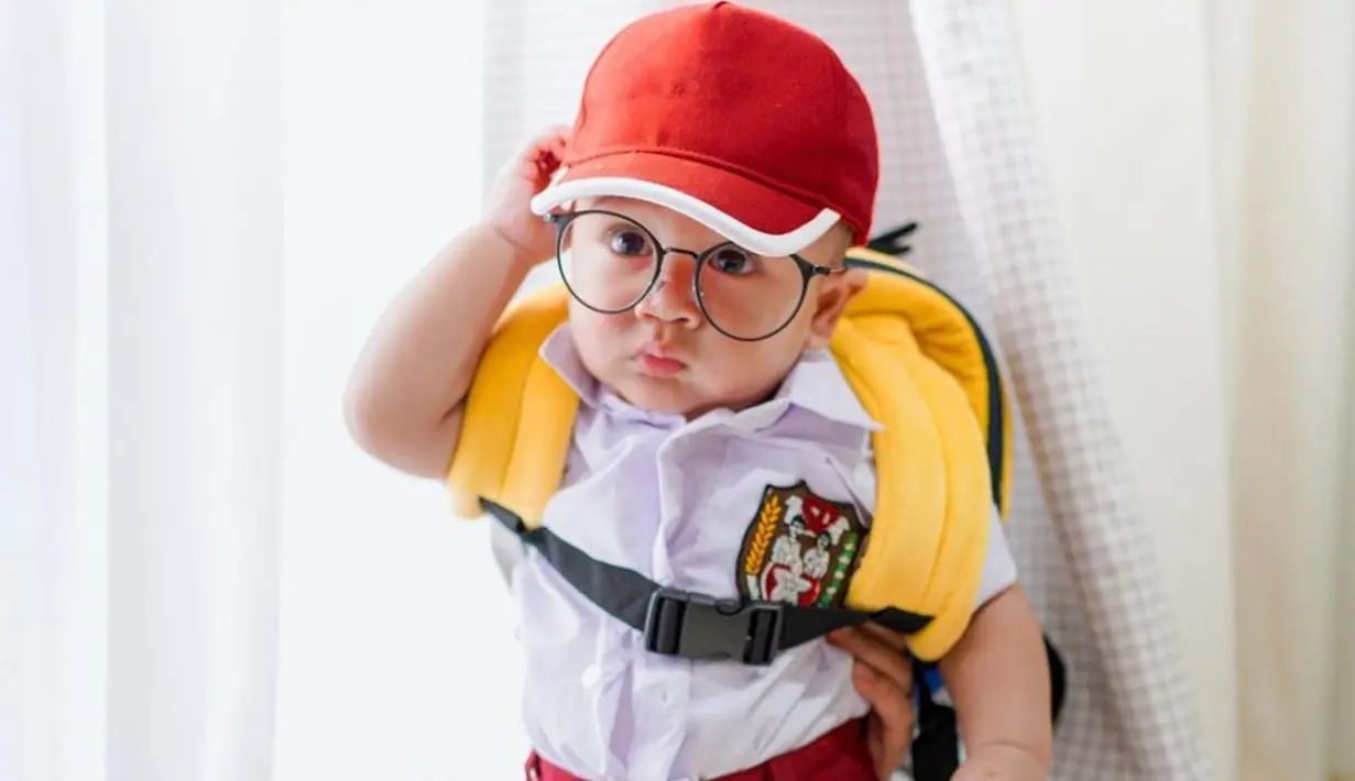 Rayyanza Malik Ahmad terkenal sebagai balita lucu yang gaya penampilannya terkenal lucu. Gaya bak anak SD ini sempat viral. Terlebih Cipung tampil lucu dengan memakai topi dan kacamata bak seorang kutu buku. (Liputan6.com/IG/raffinagita1717)