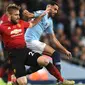 Bek Manchester United, Luke Shaw, berebut bola dengan gelandang Manchester City, Riyad Mahrez, pada laga Premier League di Stadion Etihad, Manchester, Minggu (11/11). City menang 3-1 atas MU. (AFP/Oli Scarff)