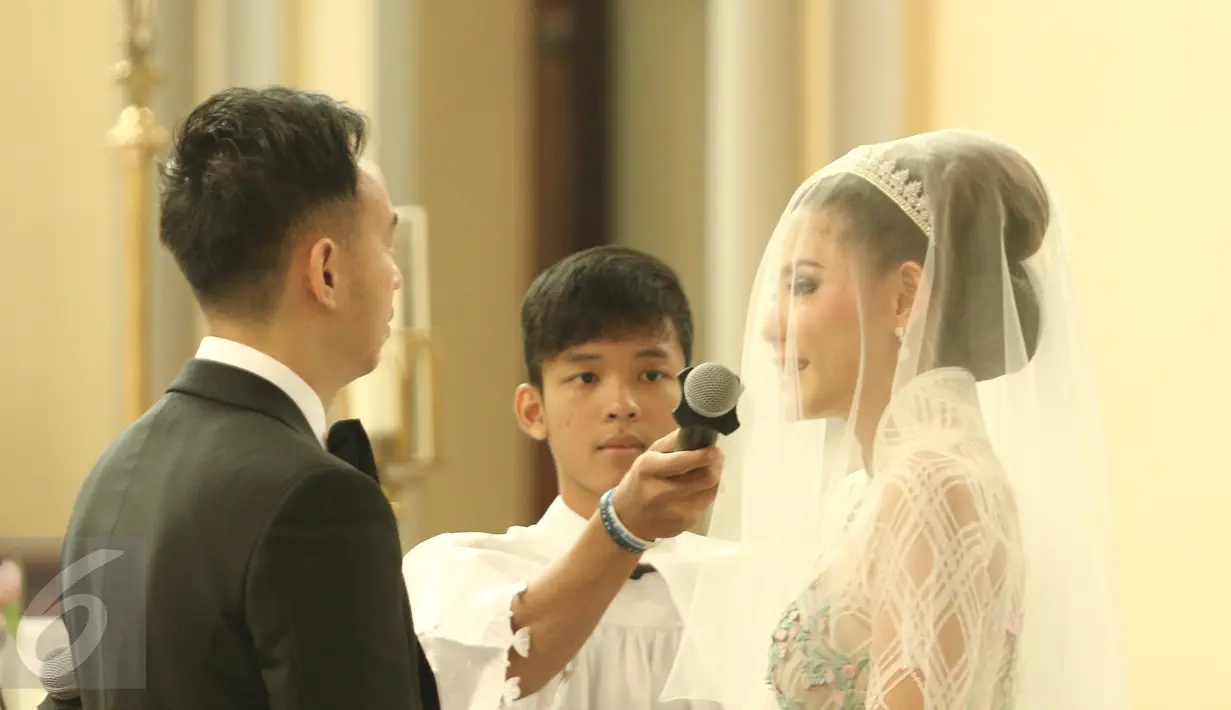 Aktris Olga Lydia dan Aris Utama sedang mengucapkan janji suci di Gereja Katedral, Jakarta, Jumat (21/4). Aktris Olga Lydia dan Aris Utama menjalankan sakramen pernikahan. (Liputan6.com/Herman Zakharia)
