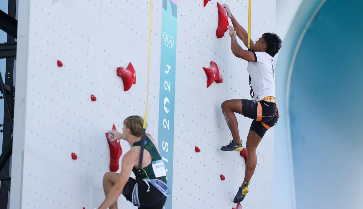 Atlet panjat tebing Indonesia, Rahmad Adi Mulyono (kanan) berlomba menghadapi wakil Afrika Selatan, Joshua Bruyns pada babak kualifikasi cabor panjat tebing nomor speed putra Olimpiade Paris 2024 di Le Bourget Climbing Venue, Paris, Selasa (6/8/2024). (Dok. NOC Indonesia)