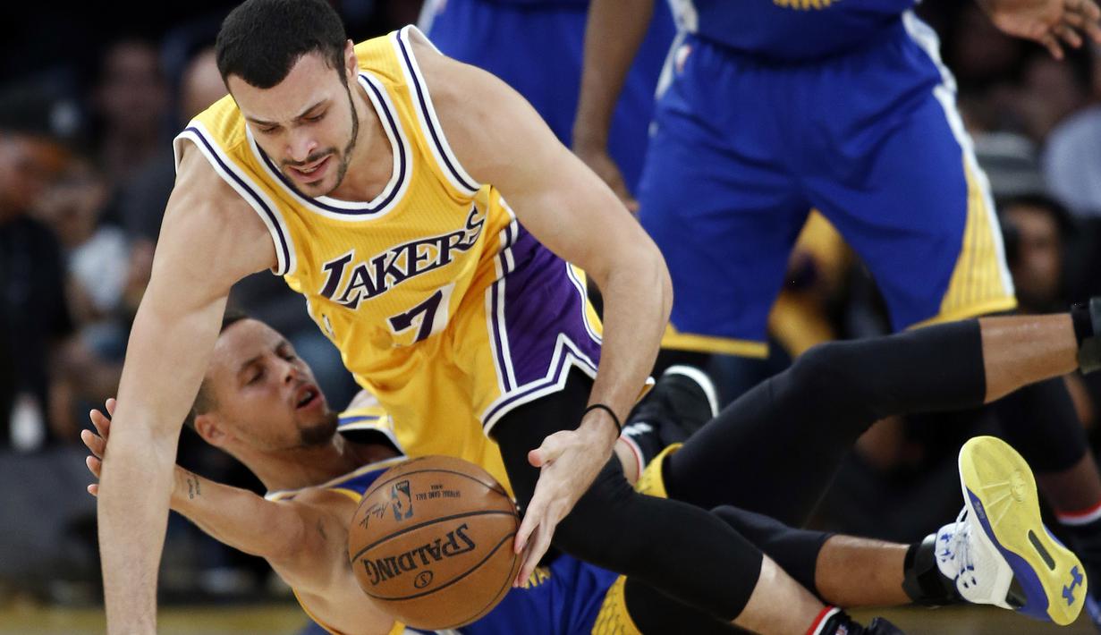 Pemain Los Angeles Lakers, Larry Nance Jr. merebut bola dari pemain Golden State Warriors, Stephen Curry (bawah) pada laga NBA basketball game di Los Angeles, (4/11/2016).  (AP /Alex Gallardo)