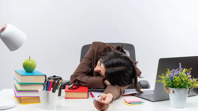Seorang perempuan tertidur di atas meja kerjanya (Foto Dok: Freepik/stockking)
