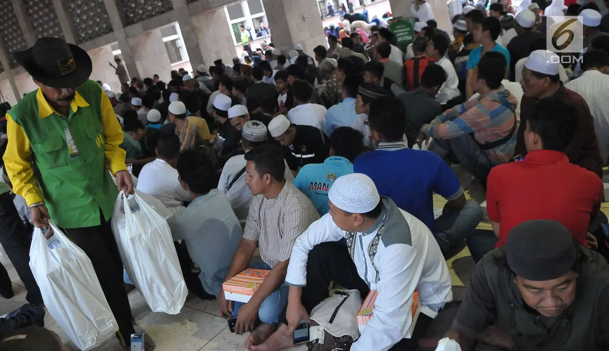  Petugas membagikan takjil jelang berbuka puasa pada hari kedua bulan Ramadan di Masjid Istiqlal, Jakarta, Minggu (28/5). Panitia masjid juga menyiapkan 3000 kotak makanan pada hari Senin - Kamis.(Liputan6.com/Helmi Afandi) 