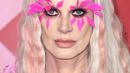 Kristen McMenamy memilih bulu mata merah muda neon yang tebal. Ini merupakan pilihan sempurna untuk rambut putih panjangnya.
