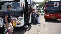 Calon penumpang bersiap menaiki bus di Terminal Kampung Rambutan Jakarta, Kamis (24/3/2022). Pemerintah memastikan bahwa masyarakat diperbolehkan mudik Lebaran tahun 2022 dengan syarat sudah mendapatkan vaksin dosis lengkap dan ketiga atau booster. (Liputan6.com/Herman Zakharia)