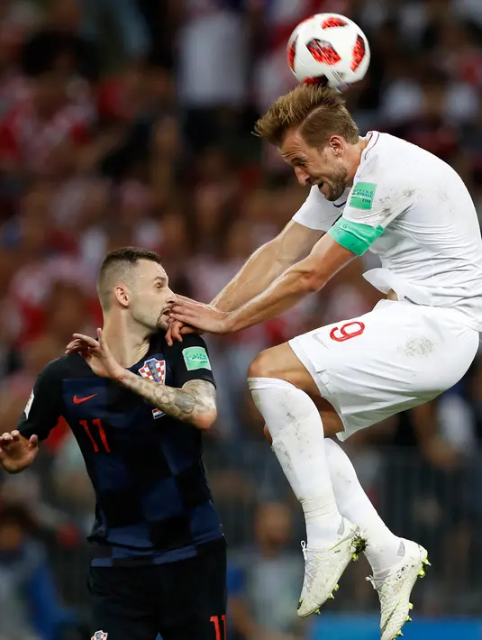 Pemain timnas Inggris, Harry Kane berebut bola dengan pemain Kroasia, Marcelo Brozovic pada babak semifinal Piala Dunia 2018 di Stadion Luzhniki, Rabu (11/7). Kroasia memastikan diri maju ke final seusai mengandaskan Inggris 2-1. (AP/ Francisco Seco)