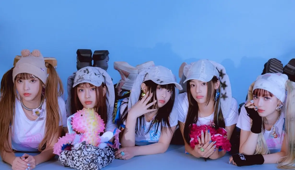 <p>Jangan lupakan penutup kepala seperti beannie, baseball cap, atau bandana yang ngetren pada tahun 2000-an. Stylist NewJeans memberi sentuhan agar penutup kepala ini mengingatkan kepada maskot grup ini, kelinci. (Twitter/ NewJeans_ADOR)</p>