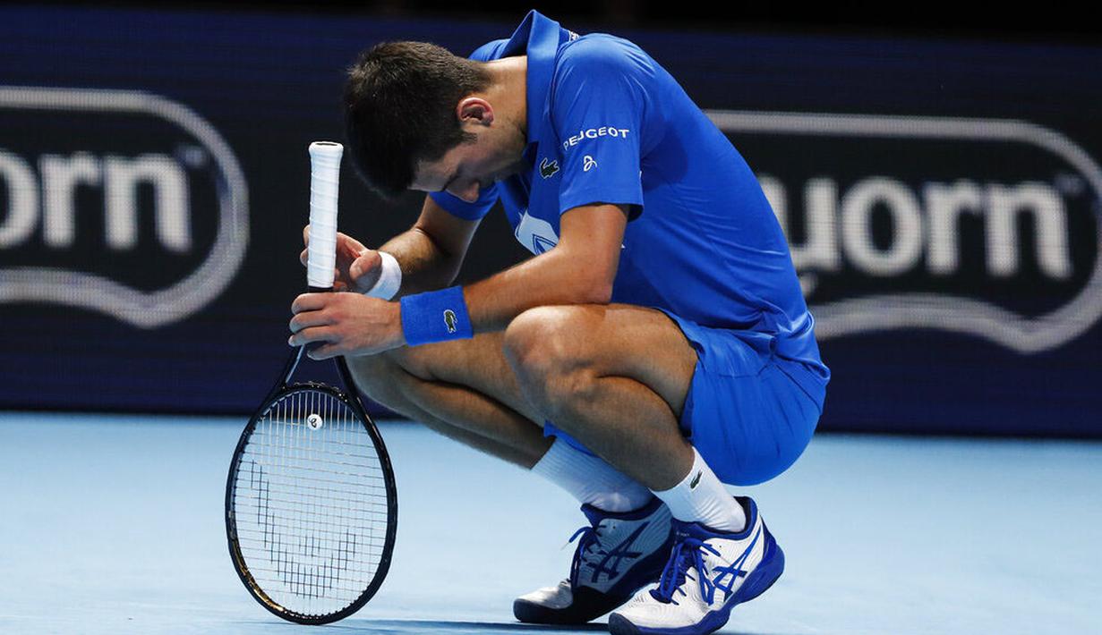 Petenis Serbia, Novak Djokovic, tertunduk lesu usai ditaklukkan Petenis Rusia, Daniil Medvedev, pada ATP Finals di O2 Arena, London, Kamis (19/11/2020). Petenis nomor satu dunia itu takluk 3-6 3-6. (AP/Frank Augstein)