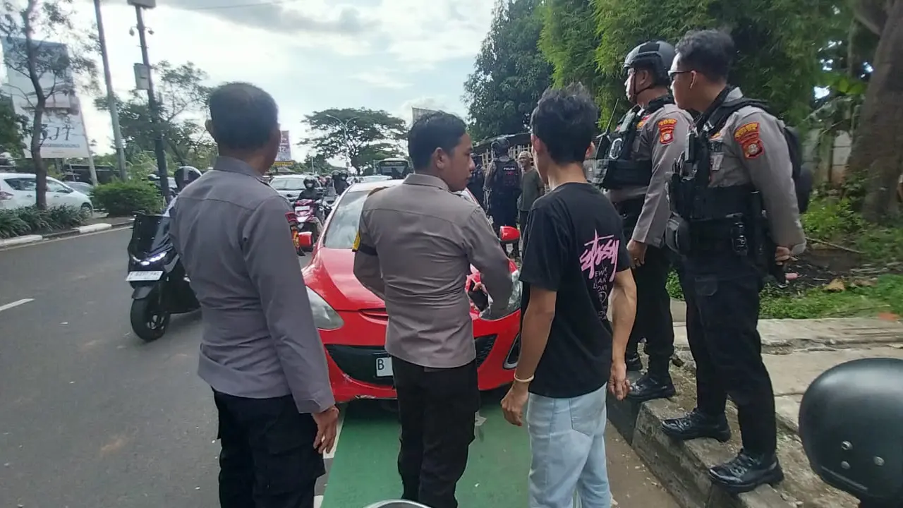 Anggota kepolisian mendatangi korban yang sempat dianiaya kelompok mata elang di Jalan Raya Juanda depan Gema Insani, Sukmajaya, Depok.