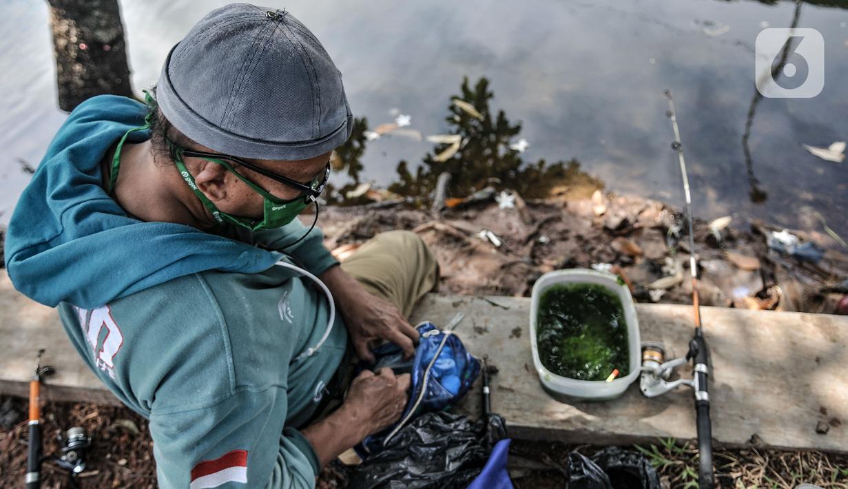Warga menyiapkan umpan saat memancing di Kali Ancol, Jakarta Utara, Kamis (11/3/2021). Ikan yang biasa didapat warga antara lain bawal dan mujair. (merdeka.com/Iqbal S. Nugroho)