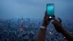 Gambar pada 19 Agustus 2019 memperlihatkan seorang turis mengambil gambar panorama skyline (kaki langit) kota Tokyo dari dek observasi Menara Roppongi Hills. Wisatawan dapat melihat berbagai gedung pencakar langit yang semua tertata rapi di kota terkenal sibuk ini. (AP Photo/Jae C. Hong)