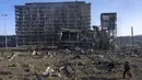 Seorang pria berjalan dengan anjingnya di tengah kehancuran setelah serangan sebuah pusat perbelanjaan di Kiev, Ukraina, Senin (21/3/2022). Delapan orang tewas dalam serangan tersebut. (AP Photo/Rodrigo Abd)