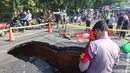 Pengendara melintas di sisi ruas jalan yang ditutup sebagian akibat amblas di Jalan Raya Lenteng Agung, Jakarta Selatan, Jumat (29/5/2026). (merdeka.com/Arie Basuki)