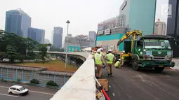 Pekerja mempersiapkan alat untuk melakukan uji beban statis dan dinamis Simpang Susun Semanggi, Jakarta, Kamis (13/7). Uji beban dilakukan guna menguji kelayakan Simpang Susun Semanggi sebelum diresmikan 17 Agustus mendatang. (Liputan6.com/Angga Yuniar)