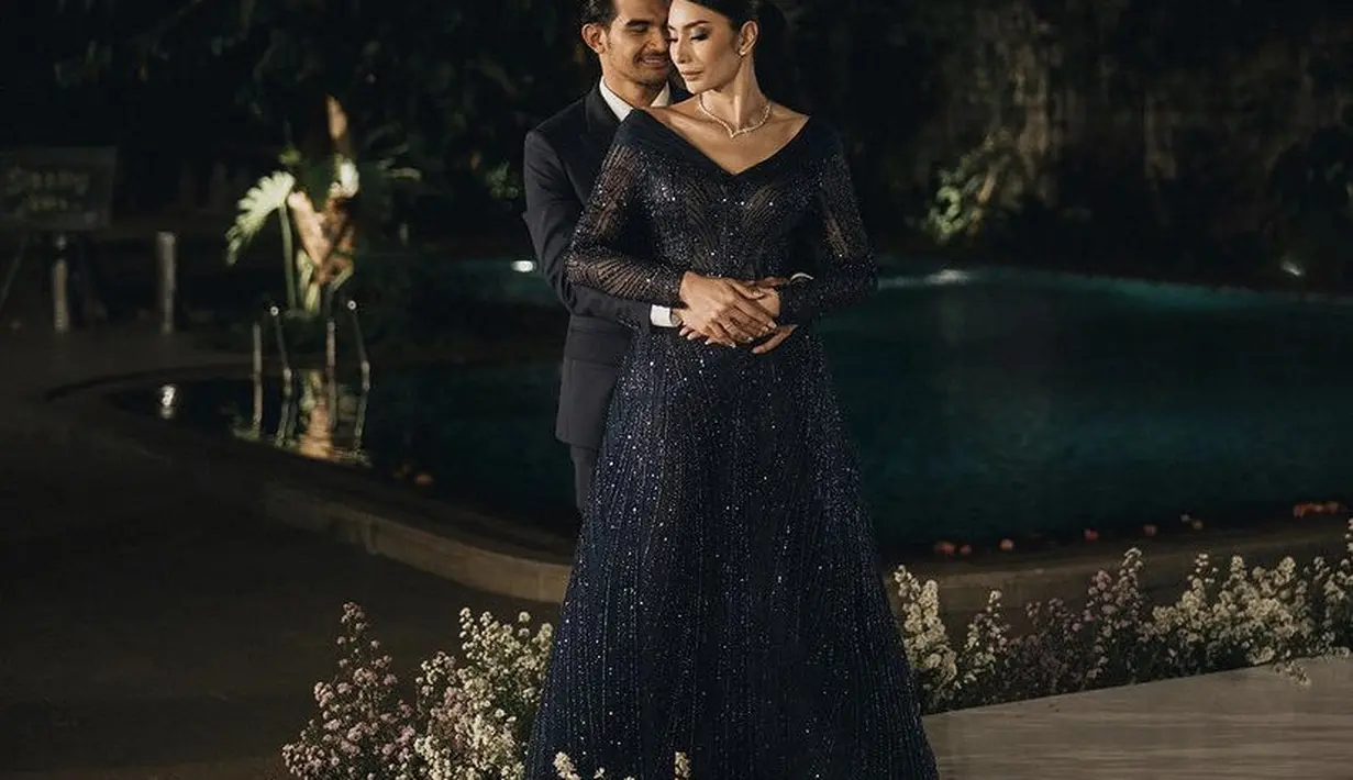 Saat resepsi pernikahan, Tyas dibalut gaun warna navy dari Didiet Maulana. Gaun lengan panjang berdada heart neck tersebut terlihat gemerlap. [@morden.co]