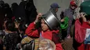 Rencana peningkatan bantuan kemanusiaan yang terperinci telah dibuat, termasuk penyediaan makanan, air bersih, tempat tinggal, dan pasokan medis, tetapi pelaksanaannya terhambat oleh pembatasan yang ada. Tampak dalam foto, warga Palestina yang terlantar, anak-anak, dan dewasa, menunggu makanan di sebuah tempat penampungan yang telah dihuni keluarga-keluarga di Nuseirat, pusat Jalur Gaza, pada 23 November 2025. (EYAD BABA/AFP)
