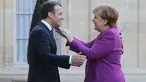 Presiden Prancis Emmanuel Macron (kiri) menyambut Kanselir Jerman Angela Merkel saat tiba di Istana Presiden Eylsee di Paris (16/3). Pertemuan tersebut untuk membahas reformasi Uni Eropa. (AFP Photo/Ludovic Marin)