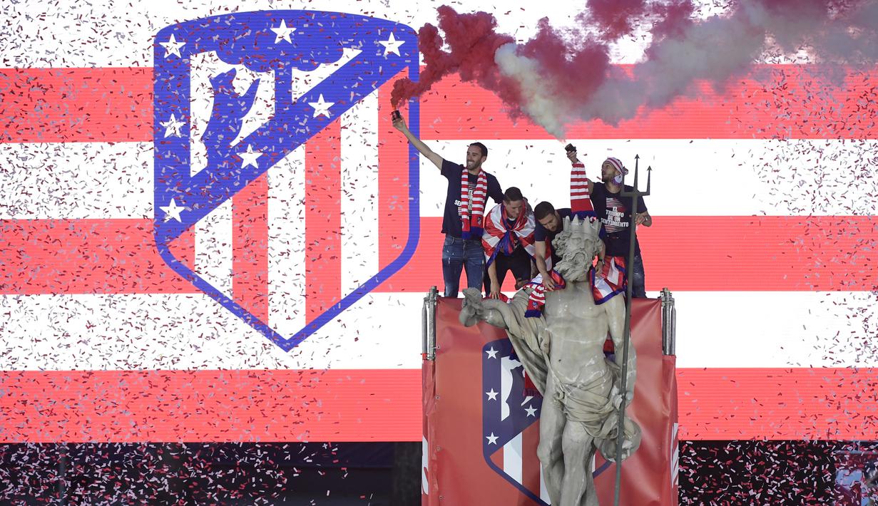 Para pemain Atletico Madrid merayakan gelar Liga Europa dengan menaiki air mancur Neptune di Madrid, Jumat (18/5/2018). Kota Madrid menjadi merah saat perayaan gelar juara Atletico. (AFP/Javier Soriano)