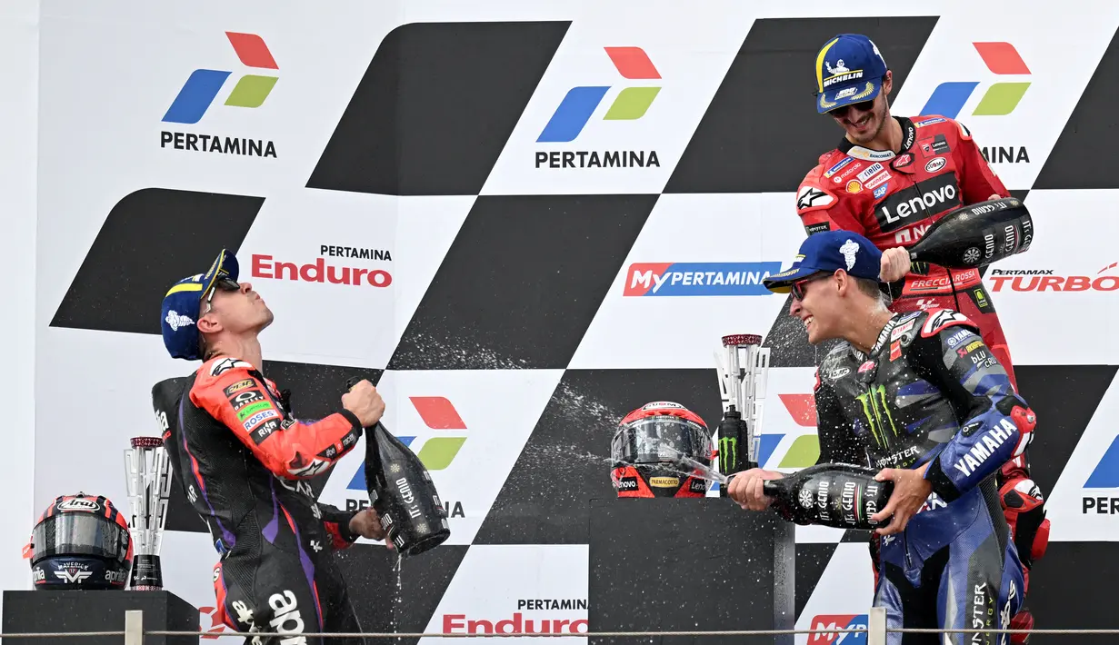 Pembalap Ducati Lenovo Team, Francesco Bagnaia (kanan atas), bersama pembalap Aprilia Racing, Maverick Vinales (kiri) dan pembalap Monster Energy Yamaha, Fabio Quartararo, melakukan selebrasi setelah menjadi juara di MotoGP Mandalika 2023, Minggu (15/10/2023) siang WIB. (AFP/Sonny Tumbelaka)