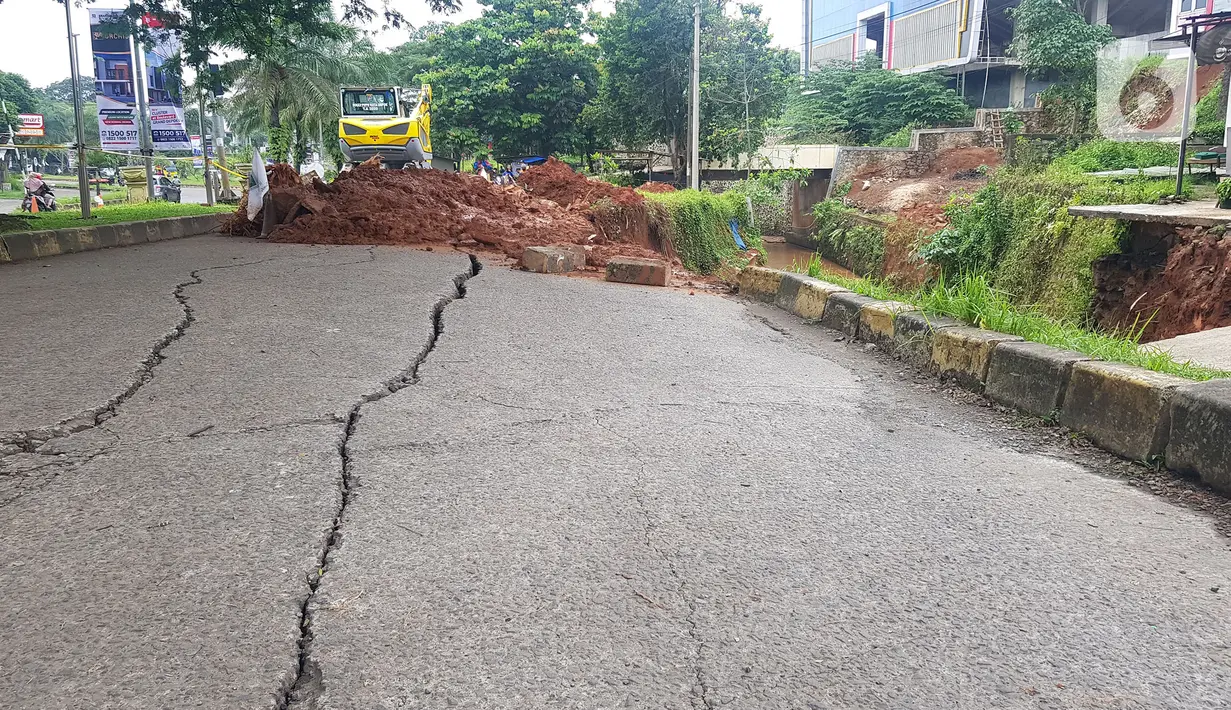 Jalan ambles di ruas Jalan Boulevard, Grand Depok City (GDC), Kota Depok, Jawa Barat, Selasa (13/4/2021). Jalan ambles terjadi setelah wilayah tersebut diguyur hujan lebat tadi malam dan mengakibatkan satu ruas jalan terpaksa ditutup sementara karena membahayakan. (Liputan6.com/Herman Zakharia)