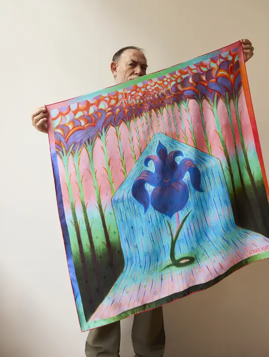 Desain Mattotti, "Iris Spring," memberi penghormatan khusus kepada warisan Louis Vuitton dengan berfokus pada bunga yang ditemukan di kaca patri rumah keluarga Vuitton. Bunga Iris diletakkan di tengah syal, digambarkan dalam warna yang cerah. [Dok/Louis Vuitton].