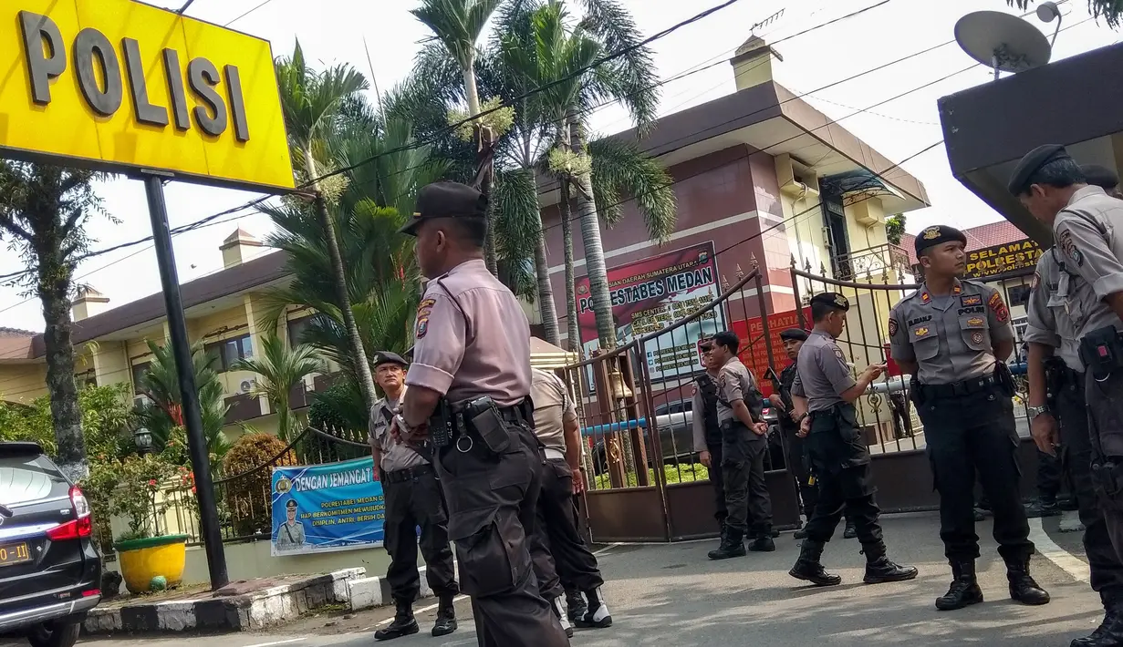Polisi berjaga setelah pelaku bom bunuh diri meledakkan dirinya di Mapolrestabes Medan, Sumatera Utara, Rabu (13/11/2019). Saat ini, aparat kepolisian sedang melakukan olah tempat kejadian perkara dan mengidentifikasi pelaku. (Rahmad SURYADI/AFP)