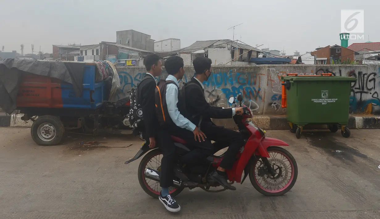 Warga melintas di depan tong sampah asal Jerman di kawasan Kampung Pulo, Jakarta, Selasa (5/6). Pengadaan tong sampah asal Jerman oleh Dinas Lingkungan Hidup DKI Jakarta ini menjadi viral di media sosial. (Merdeka.com/Imam Buhori)