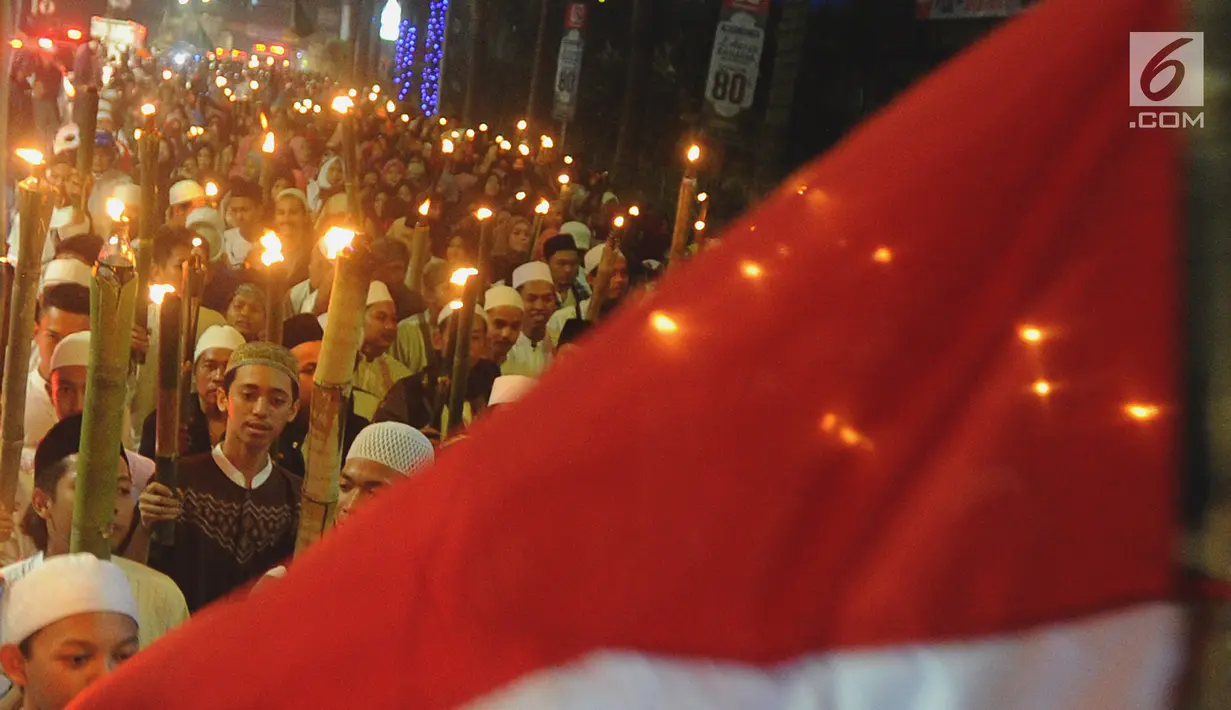 Bendera merah putih berkibar saat ratusan umat Islam dari bebagai elemen menggelar pawai obor di Empang, Bogor, Jawa Barat, Senin (14/5). (Merdeka.com/Arie Basuki)