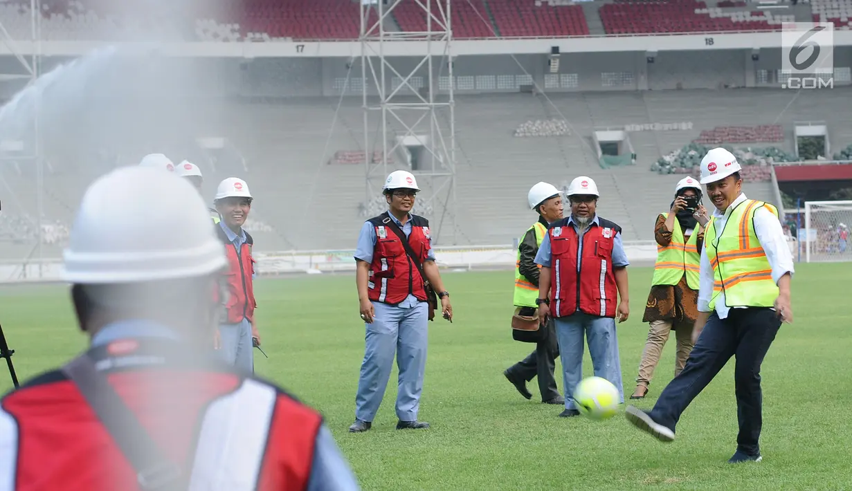 Menpora Imam Nahrawi (kanan) menendang bola saat meninjau perkembangan renovasi Stadion Utama Gelora Bung Karno, Jakarta, Selasa (8/8). Saat ini, renovasi telah mencapai 80% dan ditargetkan rampung pada akhir 2017. (Liputan6.com/Helmi Fithriansyah)