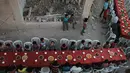 Sejumlah anak bersiap untuk berbuka puasa bersama di tengah reruntuhan bangunan di Kota Douma, yang dikuasai pemberontak di pinggiran ibukota Damaskus, Suriah, (18/6). (AFP Photo/Hamza Al-Ajweh)