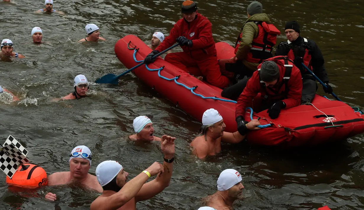 Orang-orang mengambil bagian dalam kompetisi berenang Natal tahunan di sungai Vltava, ibu kota Republik ceko, Praha, Rabu (26/12). Dalam menyemarakkan Natal, para peserta mengikuti lomba renang di sungai bersuhu dingin. (Michal CIZEK / AFP)