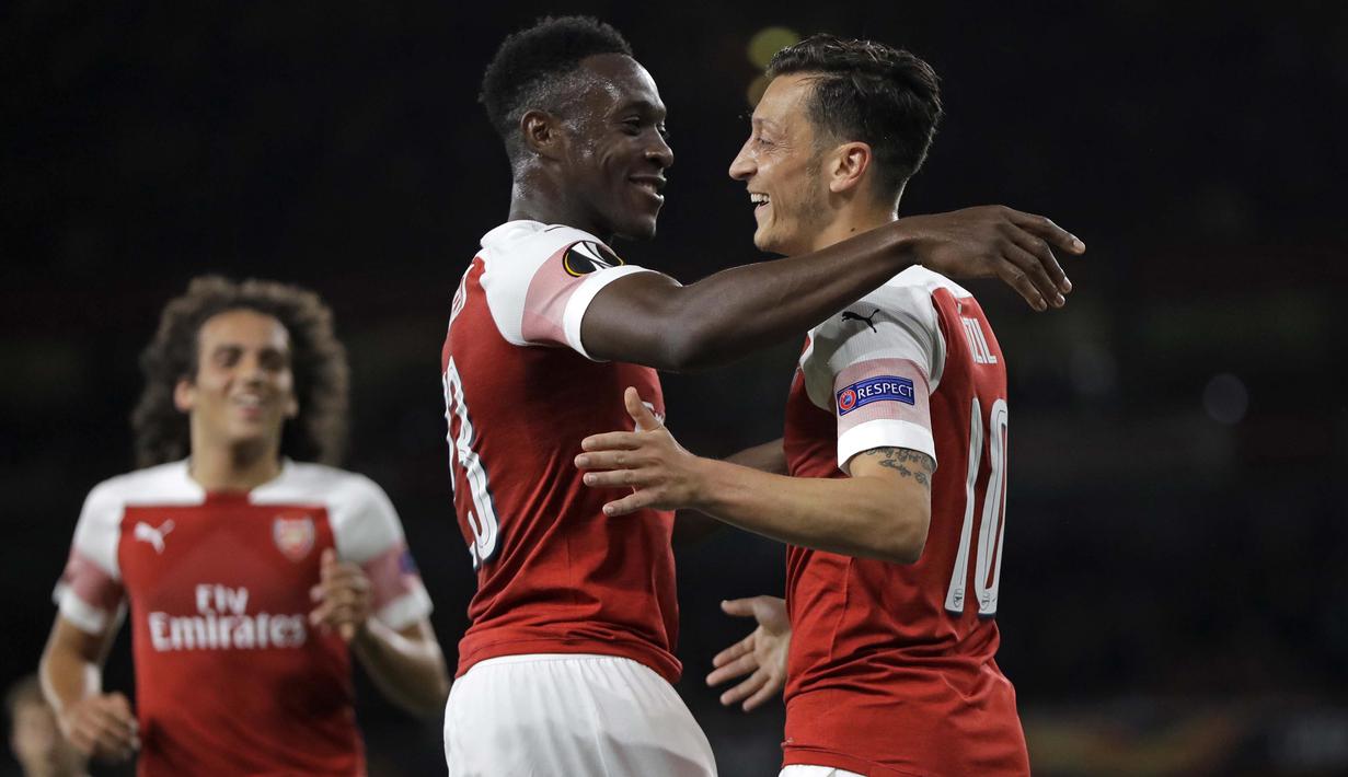 Gelandang Arsenal, Mesut Ozil, merayakan gol bersama Danny Welbeck usai membobol gawang Vorskla pada laga Liga Europa di Stadion Emirates, London, Kamis (20/9/2018). Arsenal menang 4-2 atas Vorskla. (AP/Kirsty Wigglesworth)