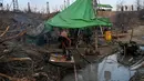 Pekerja mencuci pakaian di lokasi pengeboran sumur minyak ilegal di Minhla, Myanmar, 10 Maret 2019. Pengebor ilegal di Myanmar berpindah dari satu sumur ke sumur lainnya. (Ye Aung THU/AFP)