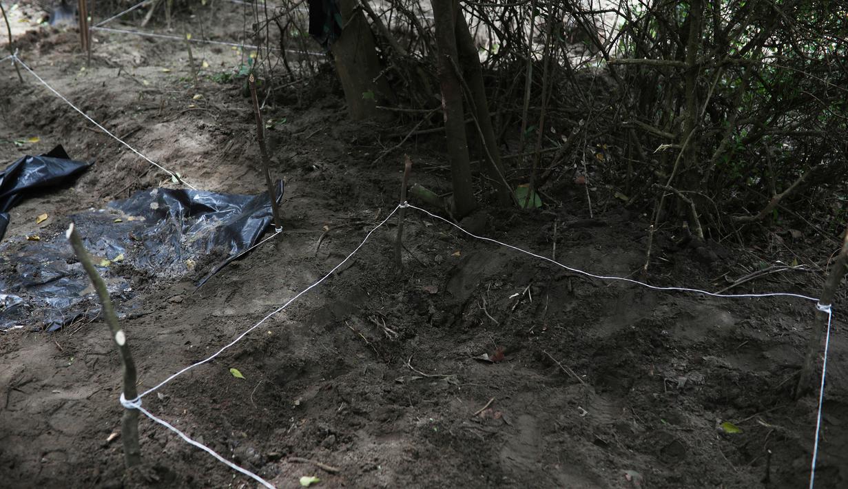 Pihak berwenang menutup area kuburan massal rahasia yang ditemukan di Arbolillo, negara bagian Veracruz, Meksiko, Jumat (7/9). Jaksa penuntut dari pengadilan Mekssiko menyebut penemuan tersebut berasal dari laporan seorang saksi. (AP/Felix Marquez)