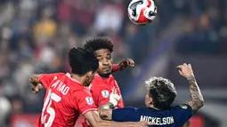 Pemain naturalisasi baru Vietnam, Nguyen Xuan Son (tengah) berduel udara dengan pemain Thailand, Nicholas Mickelson dalam laga leg pertama final Piala AFF 2024 yang berlangsung di Viet Tri Stadium, Vietnam, Selasa (02/01/2025) waktu setempat. (AFP/Nhac Nguyen)