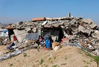 Menurut Trump, Dewan Perdamaian Gaza dirancang untuk mengawasi pembentukan pemerintahan teknokrat Palestina yang masih akan dibentuk, sekaligus memantau proses rekonstruksi di Jalur Gaza. Tampak dalam foto, para pengungsi Palestina hidup di tengah reruntuhan rumah dan bangunan yang hancur akibat serangan militer Israel selama lebih dari dua tahun di wilayah Gaza, di kamp pengungsi Jabalia, di bagian utara Jalur Gaza pada Sabtu 17 Januari 2026. (Omar AL-QATTAA/AFP)