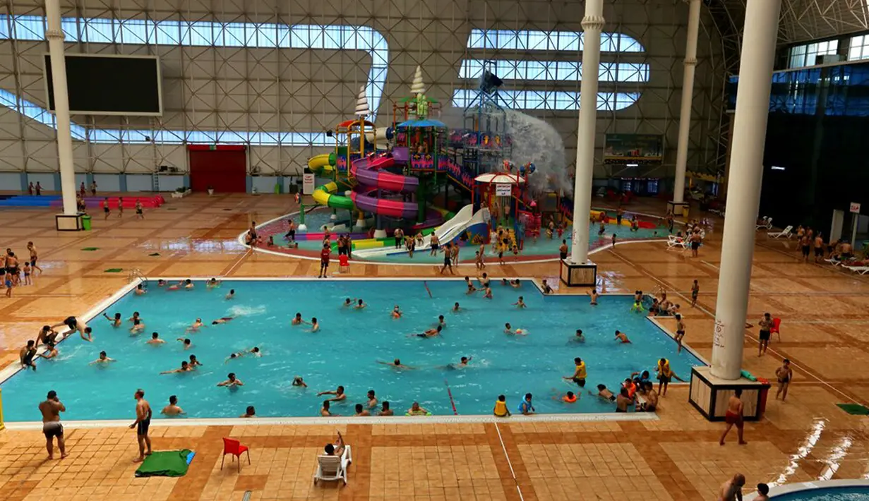 Orang-orang melarikan diri dari cuaca panas di Baghdad Aquatic Center, Baghdad, Irak, Kamis (1/7/2021). Pemerintah Irak menetapkan 1 Juli 2021 sebagai hari libur resmi di Baghdad karena gelombang panas yang menyengat. (AP Photo/Khalid Mohammed)