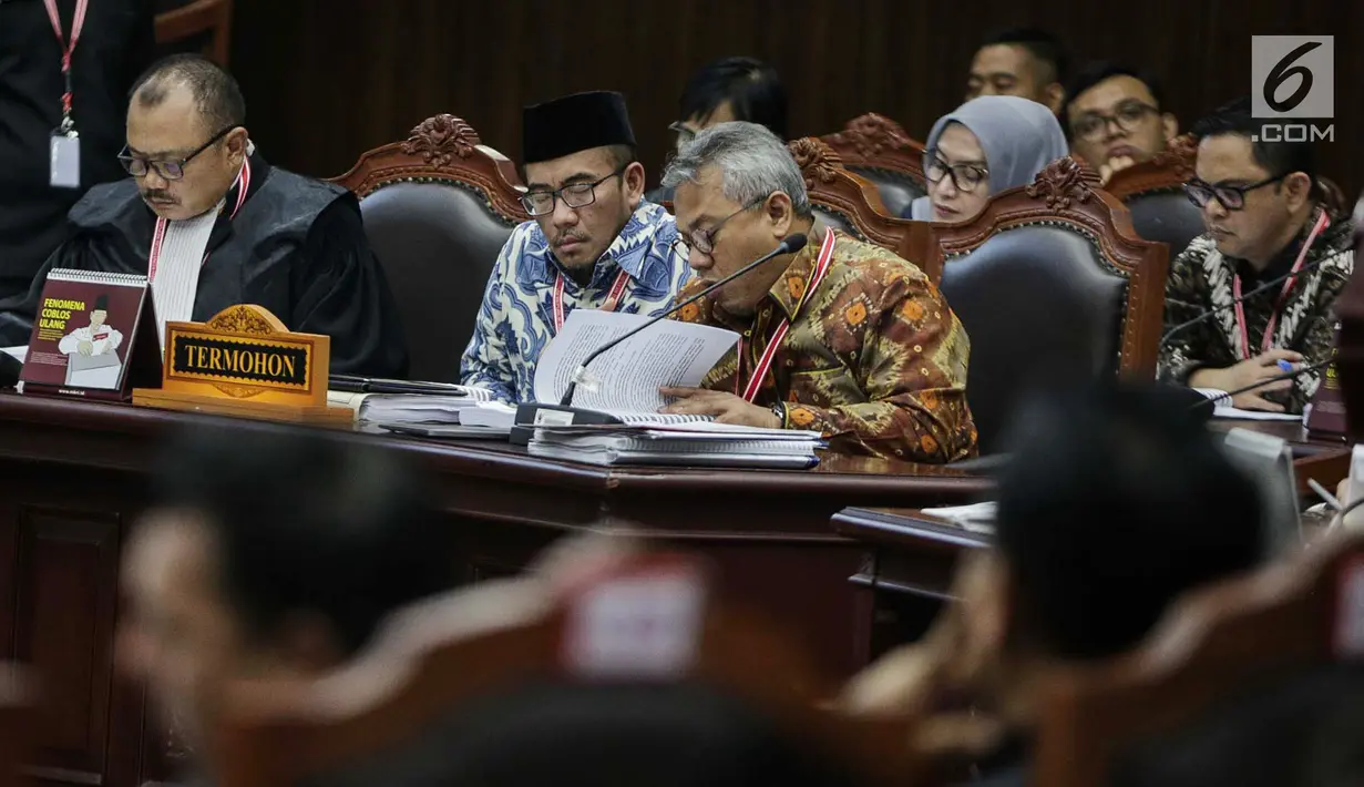 Ekspresi Ketua KPU Arief Budiman (kanan) saat mengikuti sidang sengketa Pilpres 2019 di Gedung MK, Jakarta, Selasa (18/6/2019). Sidang tersebut beragendakan mendengarkan jawaban dari termohon. (Liputan6.com/Faizal Fanani)