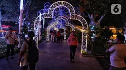 Pengunjung berfoto dengan dekorasi Natal menghiasi mal Central Park, Jakarta, Rabu (11/12/2019). Sejumlah pusat perbelanjaan di Jakarta mulai memasang dekorasi Natal untuk menarik minat pengunjung agar datang dan berbelanja. (Liputan6.com/Johan Tallo)